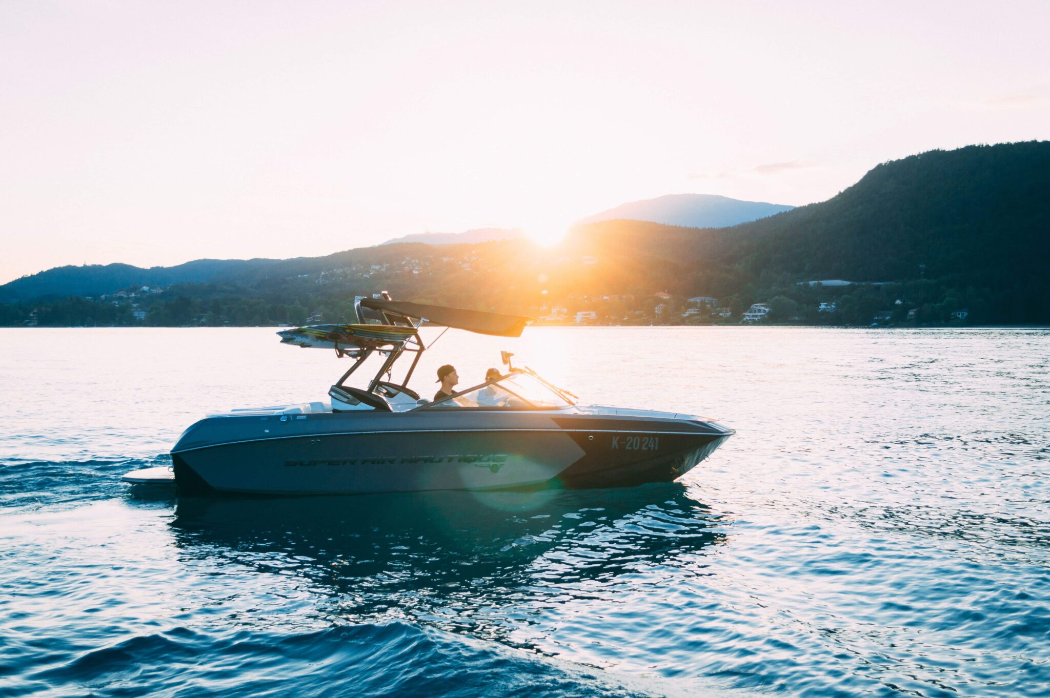 Understanding the basics of a boat and boat buying shown with an image of a water ski boat close to the mountians